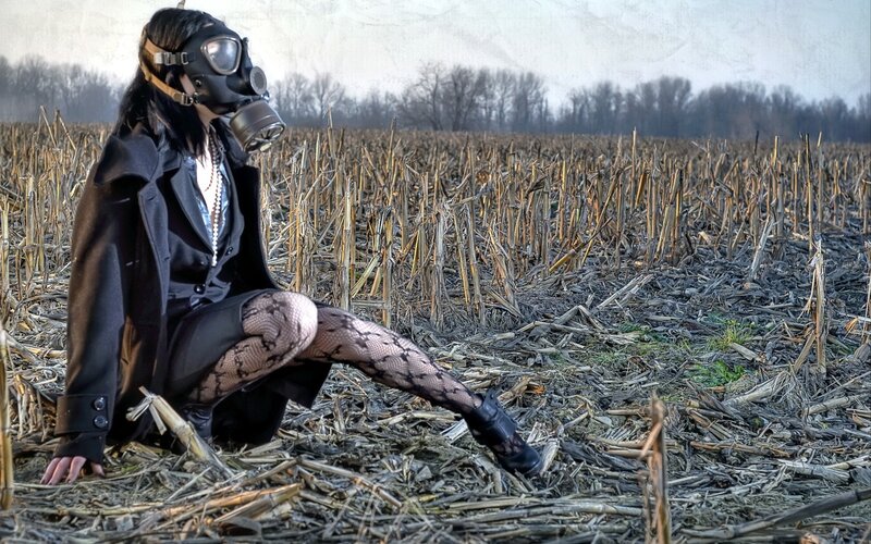 person in gas mask in field