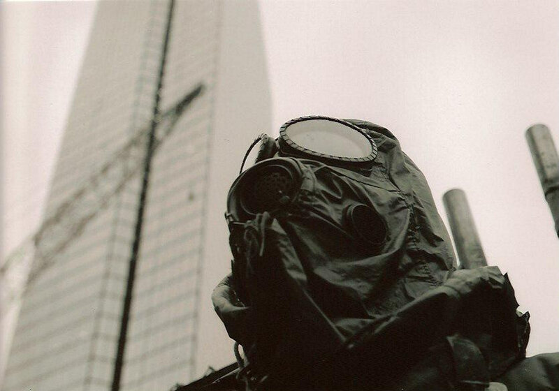 person in gas mask near skyscraper