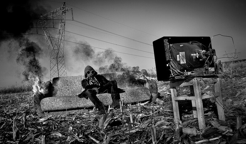 person in gas mask on burning couch