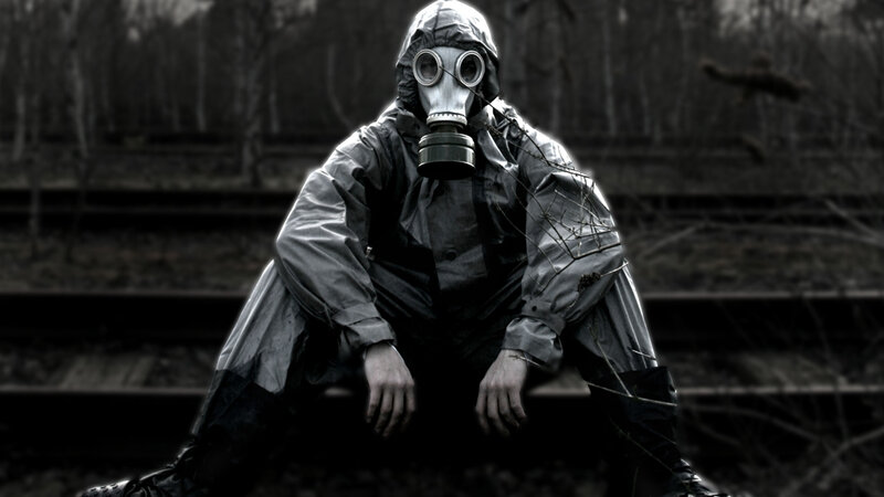 person in gas mask on train tracks