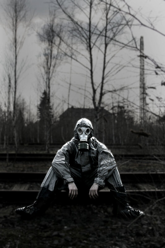 person in gas mask on train tracks