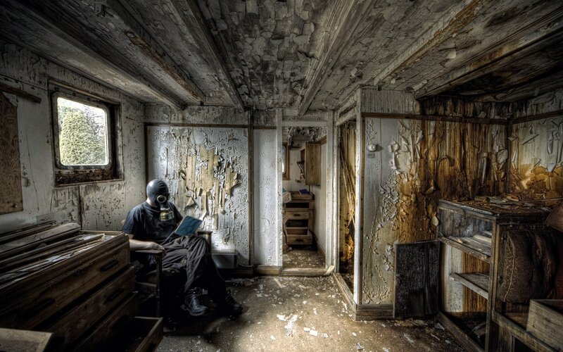 person in gas mask reading book