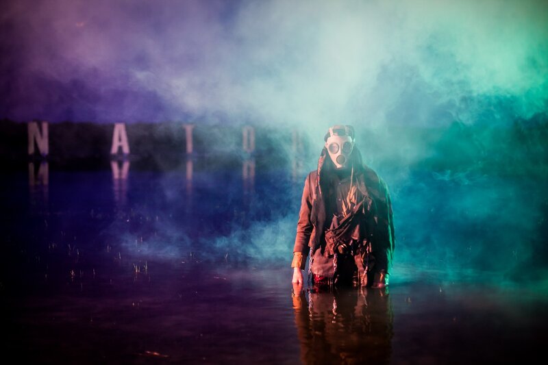 person in gas mask standing in water