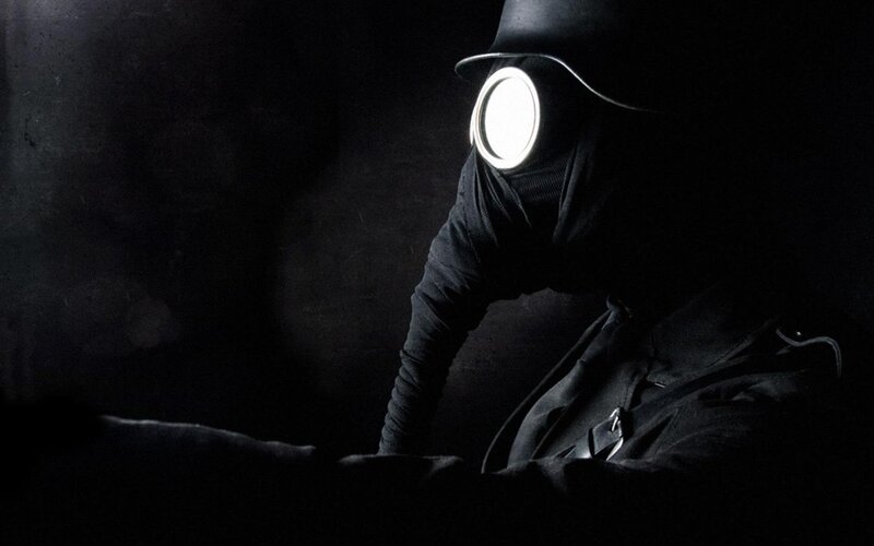 person in gas mask with light