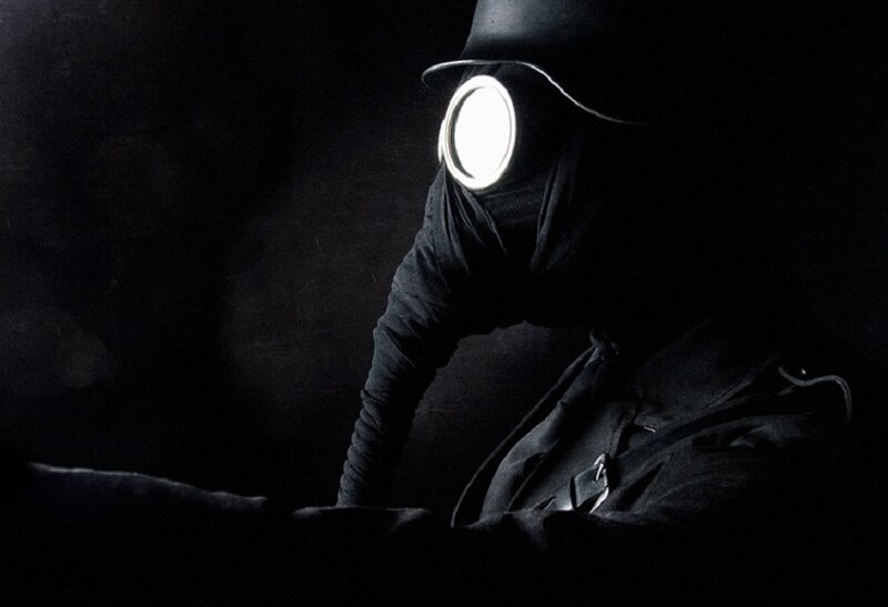 person in gas mask with light
