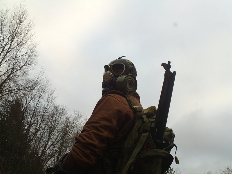 person in gas mask with rifle
