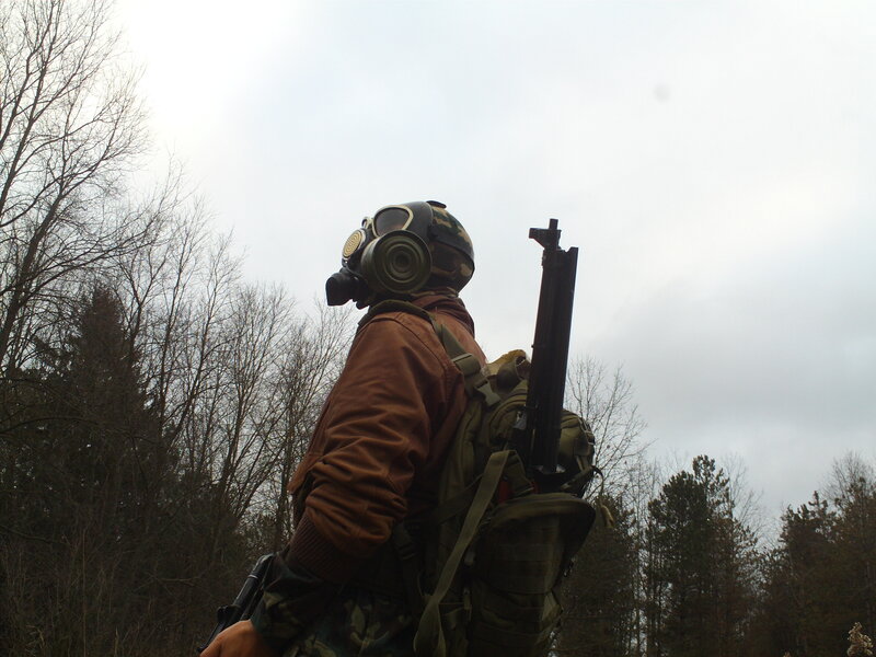 person in gas mask with rifle