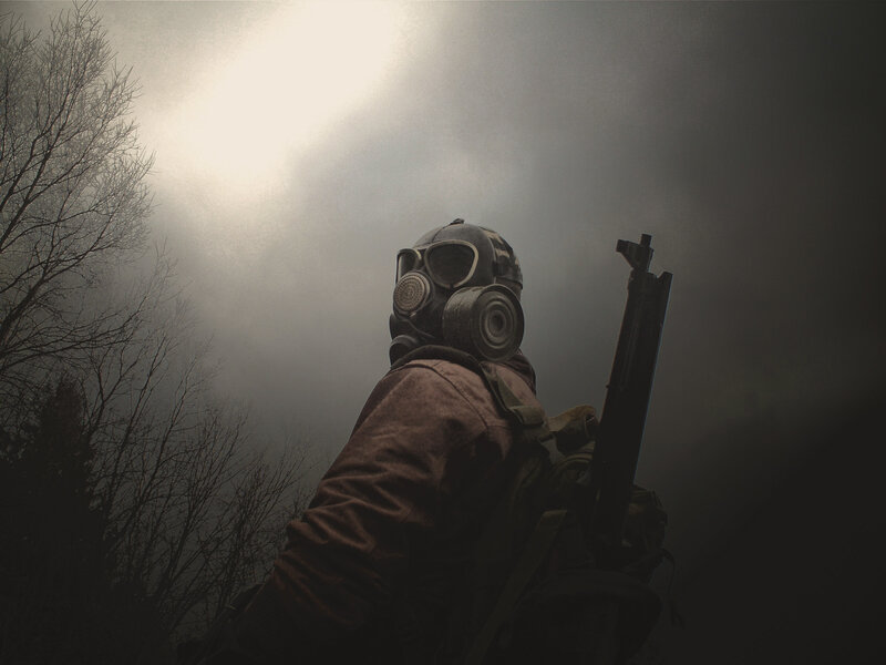 person in gas mask with rifle