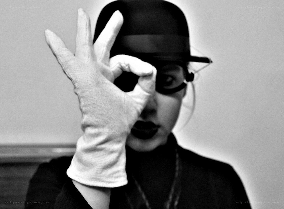 person in hat making hand gesture