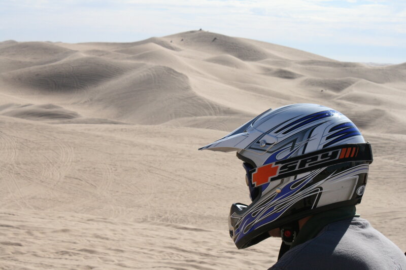 person in helmet on sand dunes
