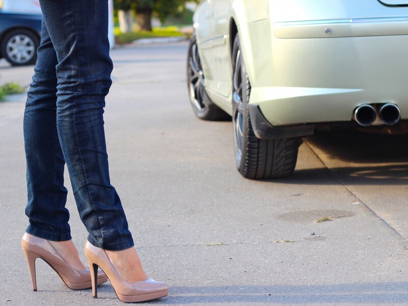 person in high heels near car