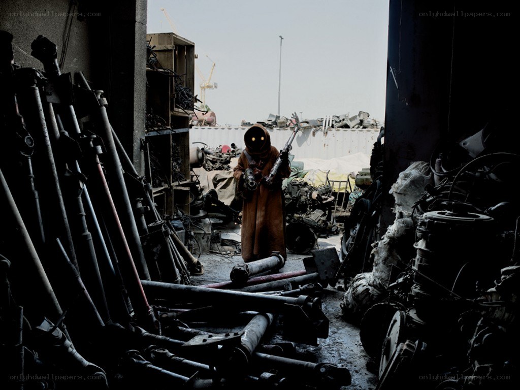 Person in hooded cloak with weapon