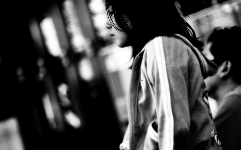 Person in Hooded Jacket — Black, Dramatic, Photograph, Blurry Background