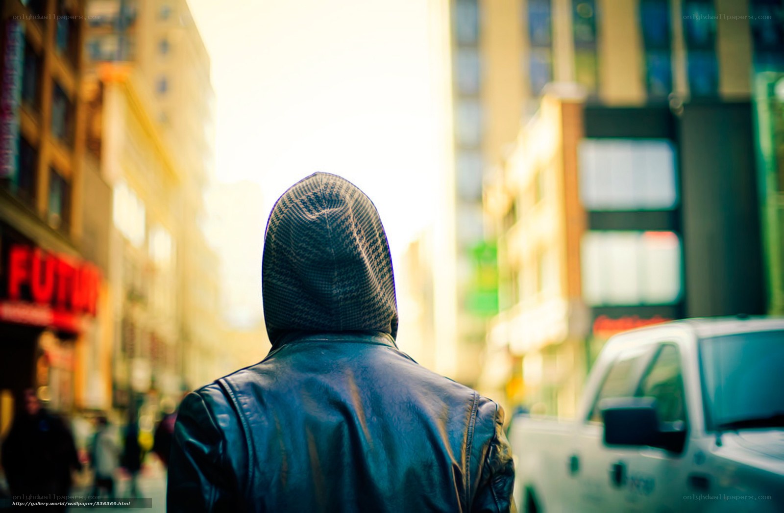 person in hoodie walking city street