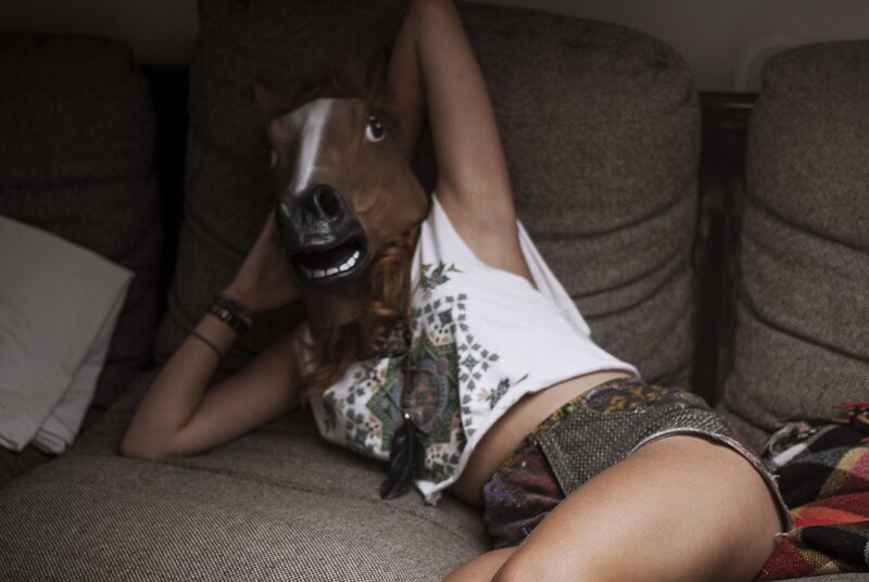 person in horse mask on couch