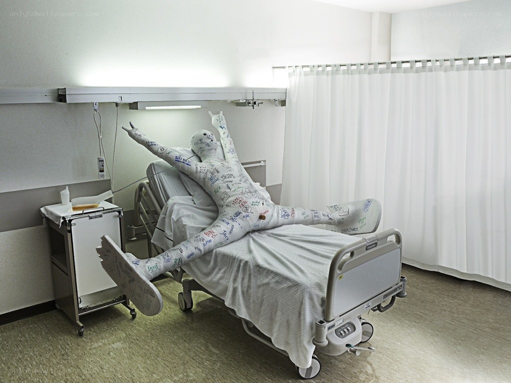 Person in hospital bed with casts