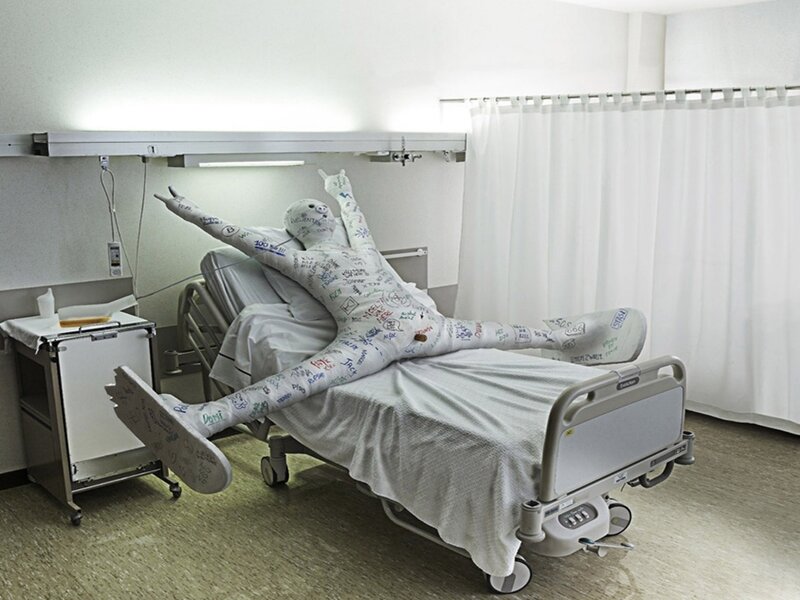 person in hospital bed with casts