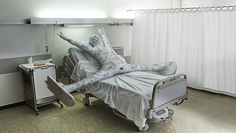 Person in hospital bed with casts