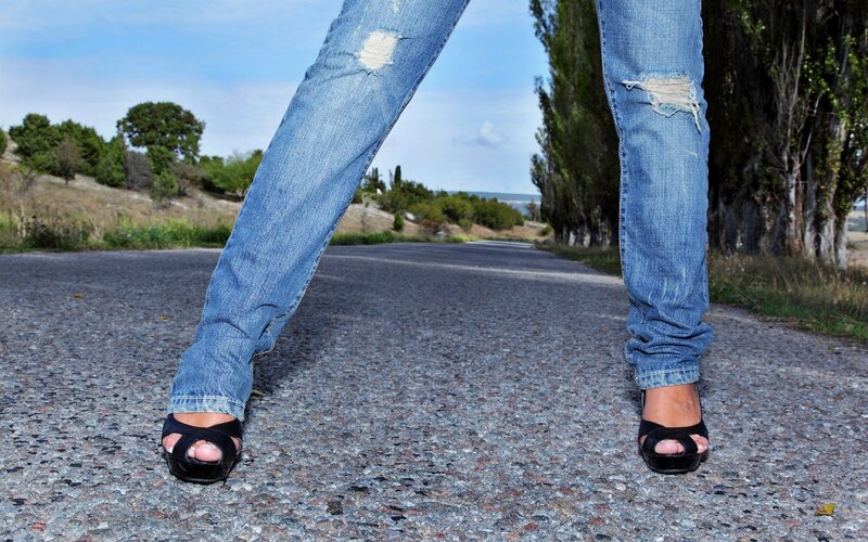 person in jeans on a road