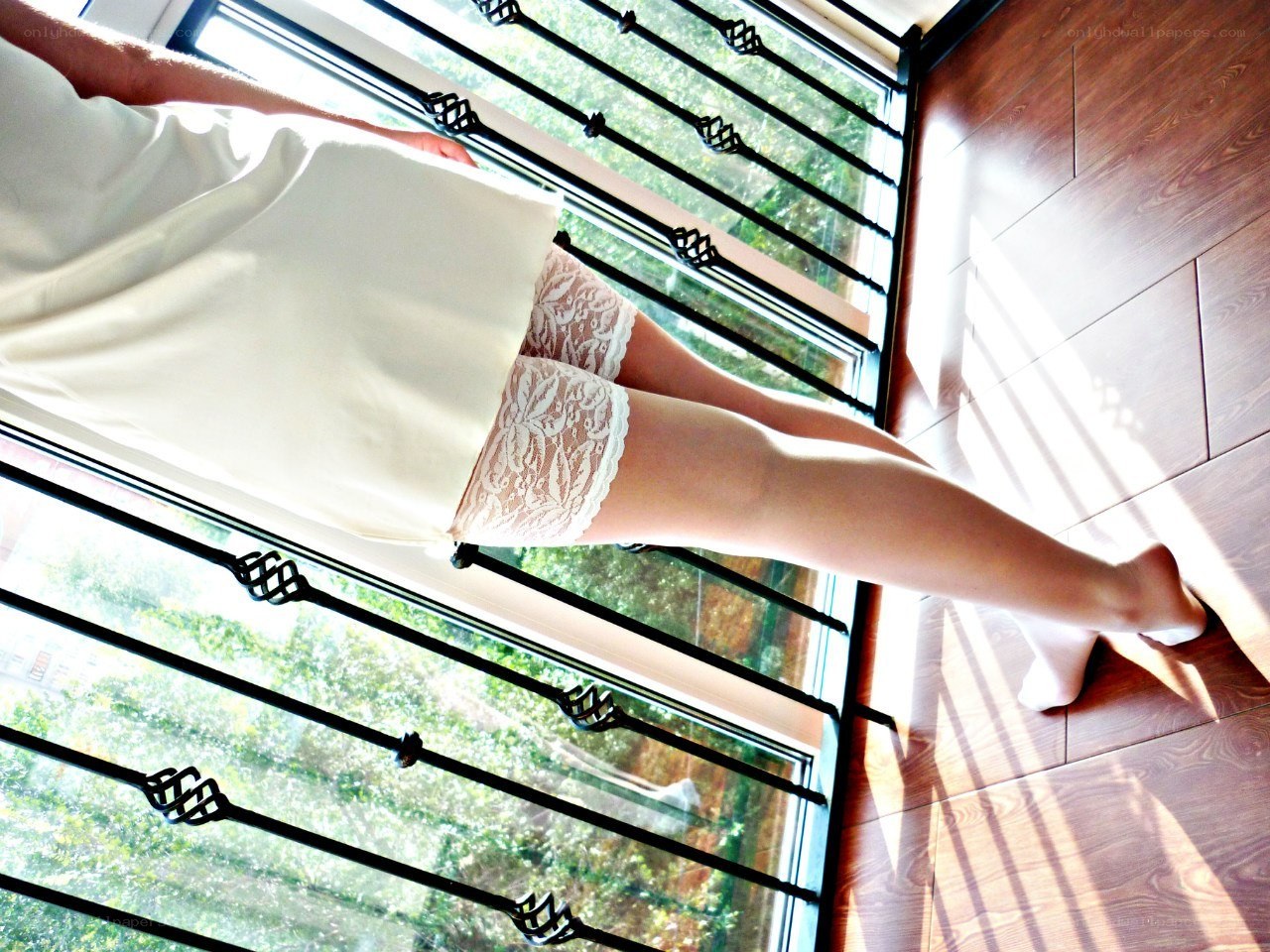 person in lace shorts by window