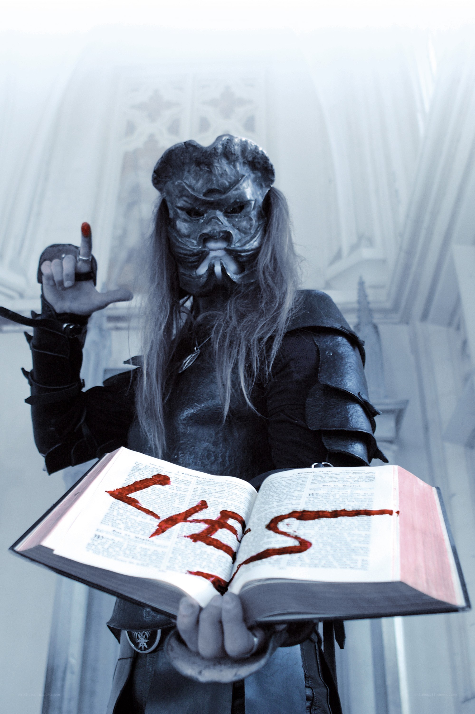 person in mask holding book