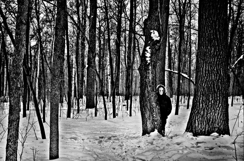 person in mask in snowy forest
