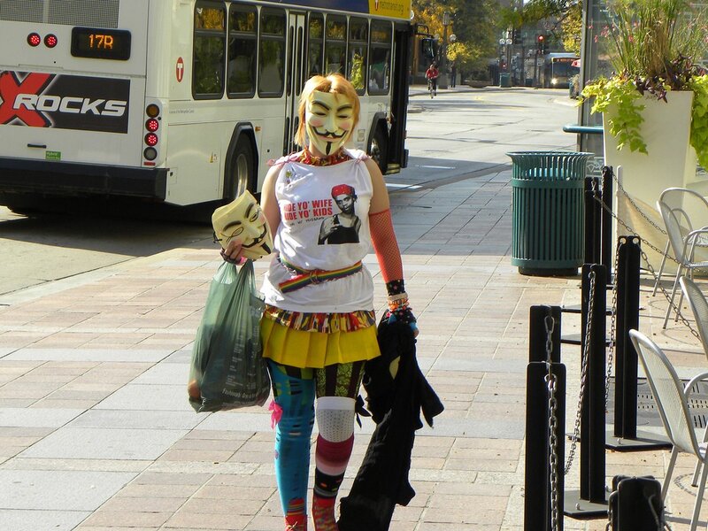 person in mask on city sidewalk