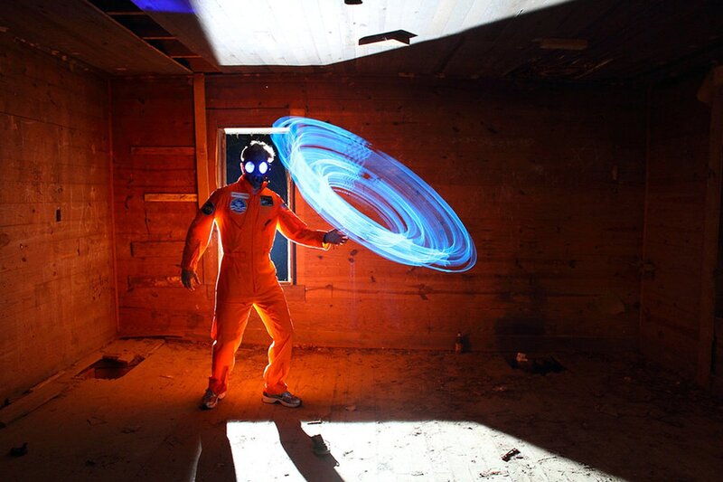 person in orange suit with light art