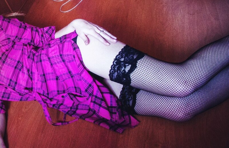 person in plaid skirt and fishnet stockings