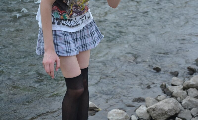 person in plaid skirt by river