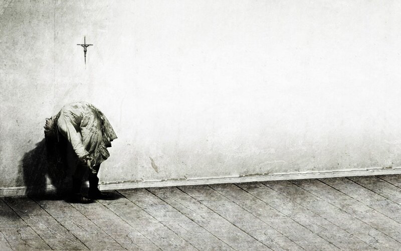 person in prayer against a wall