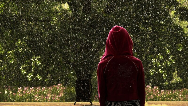 person in rain with hood up