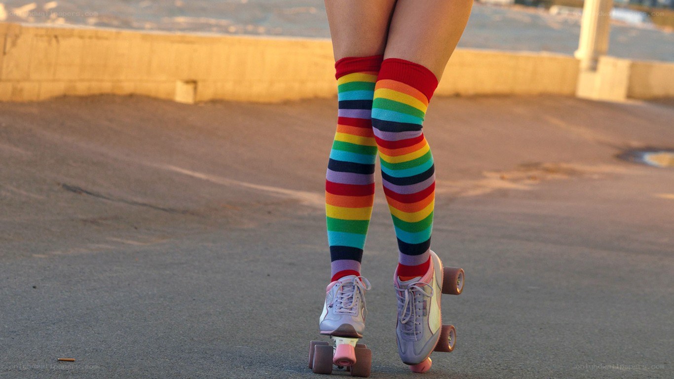 person in rainbow socks on roller skates