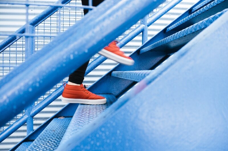 person in red shoes on blue stairs
