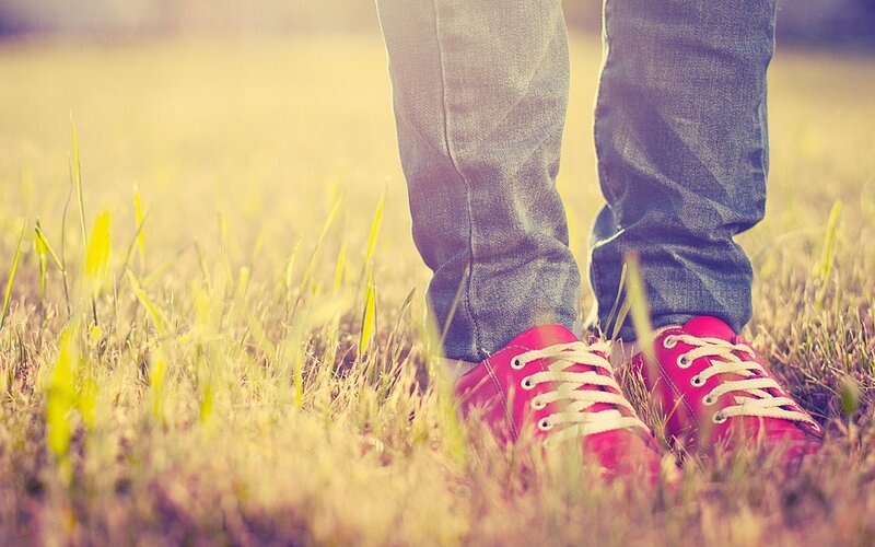 person in red shoes on grass