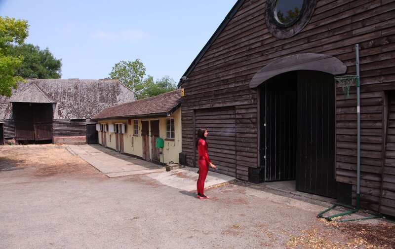 Person in red suit near barn