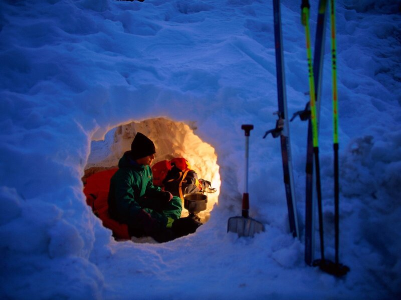 Person in snow shelter at night