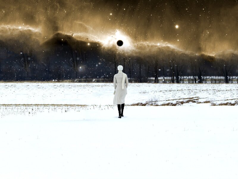 Person in snowy field under starry sky