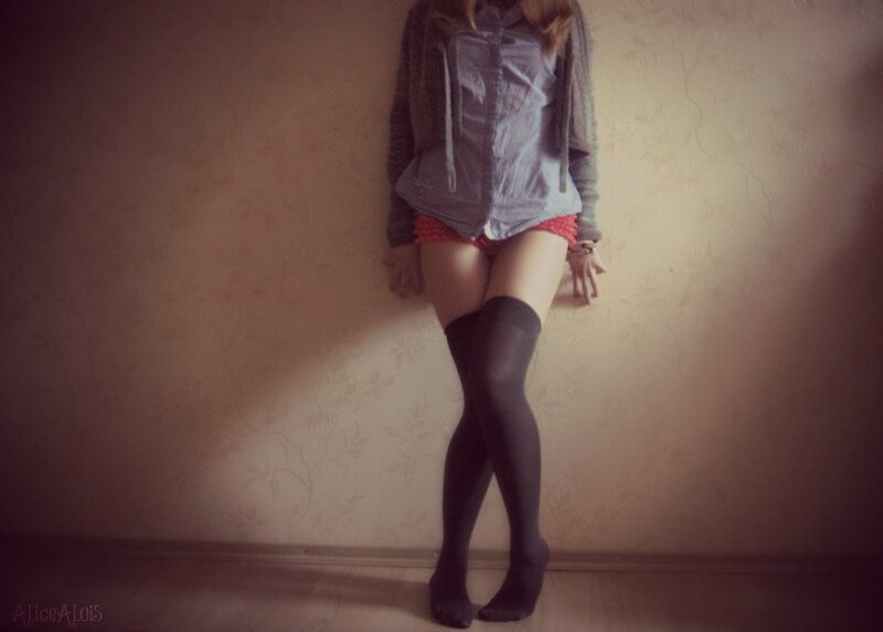person in stockings leaning against wall