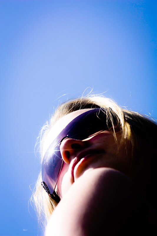person in sunglasses against blue sky