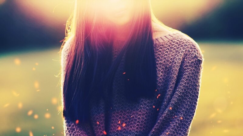 person in sweater with sun flare