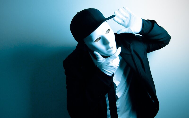 person in white mask and black suit