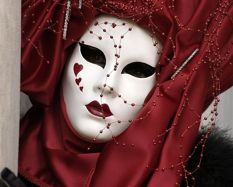 person in white mask with red veil