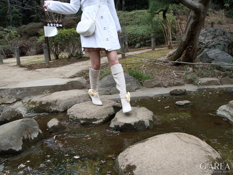 person in white outfit crossing stream
