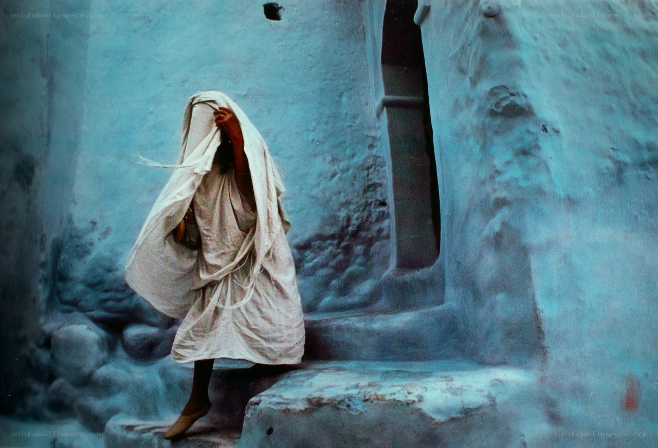 Person in white robe on steps