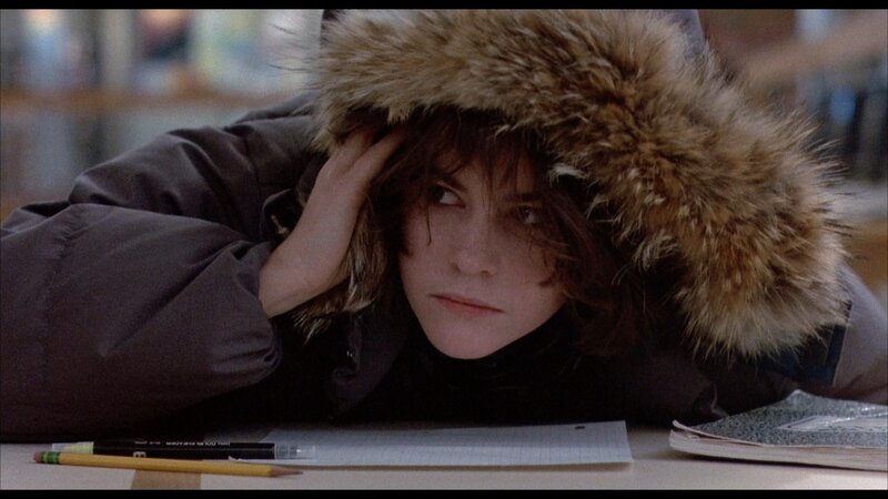 person in winter coat at desk