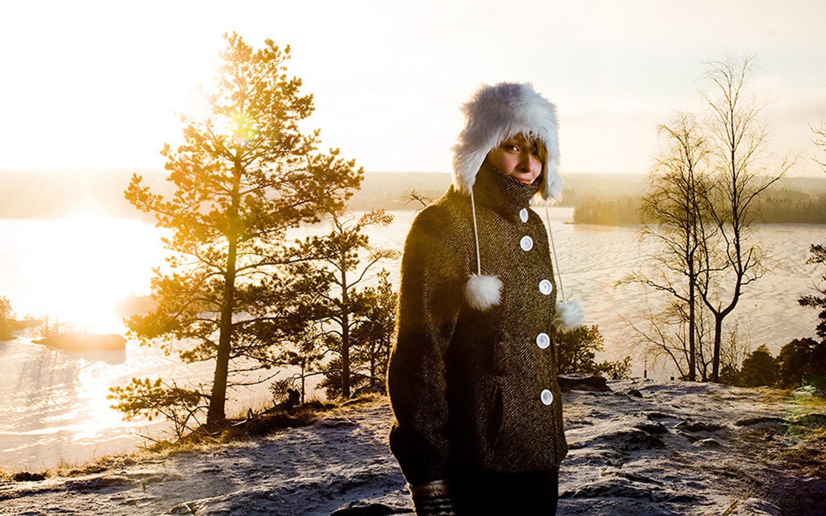 Person in winter coat by lake