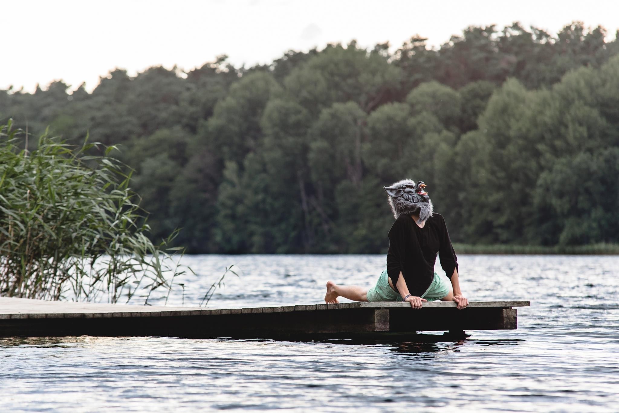 person in wolf mask on dock