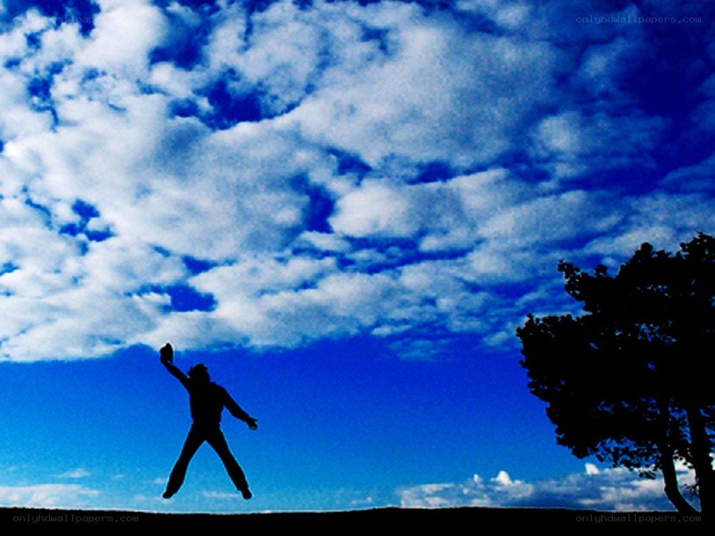 person jumping against blue sky