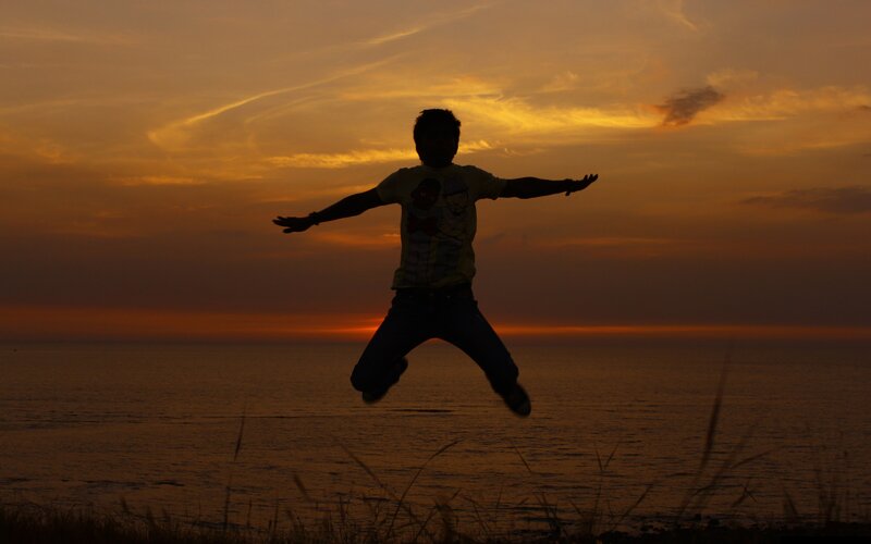 Person jumping at sunset